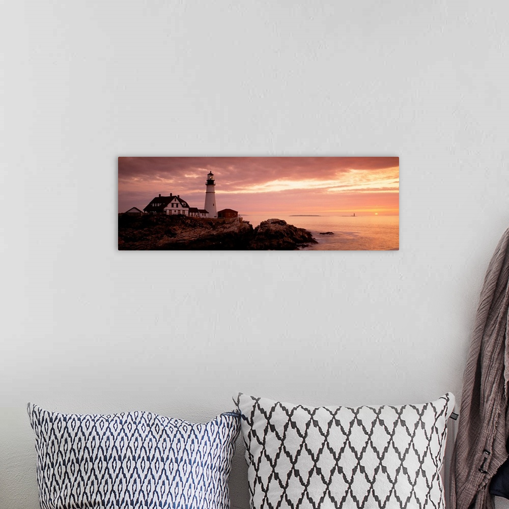 A bohemian room featuring Panoramic photograph displays the dim light of the sun as it covers the rocky shores of a beach t...