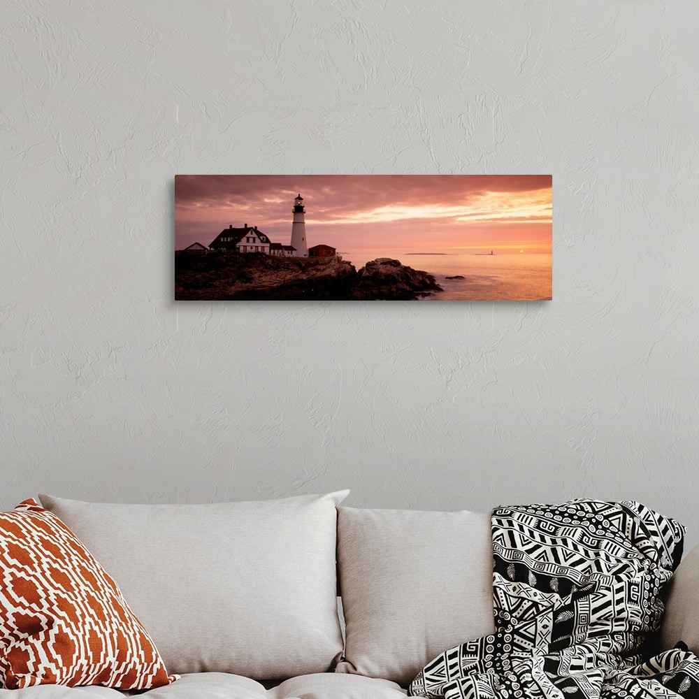 A bohemian room featuring Panoramic photograph displays the dim light of the sun as it covers the rocky shores of a beach t...
