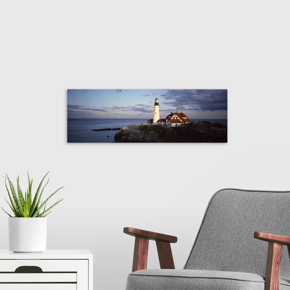 A modern room featuring Panoramic photograph of watchtower and house on huge rock formation surrounded by ocean under a c...
