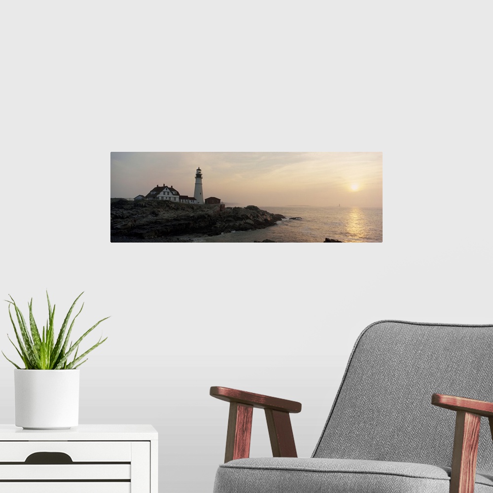 A modern room featuring Wide angle photograph of a lighthouse sitting on a cliff that reaches far out into the ocean. The...