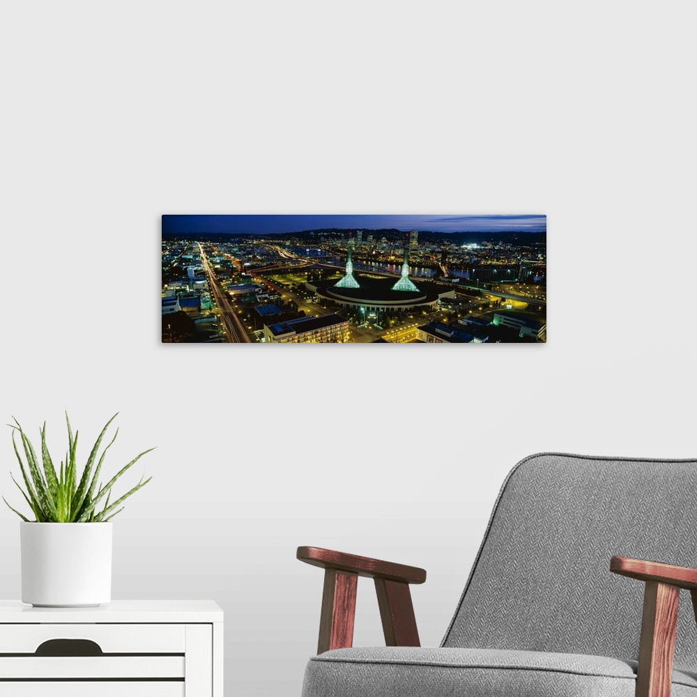 A modern room featuring Oregon's most populous city lit up in the evening by the glowing lights of office buildings and t...