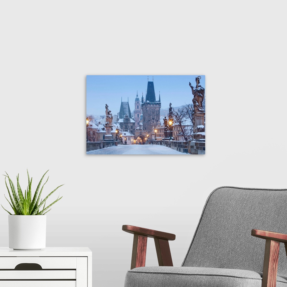 A modern room featuring Prague, Charles Bridge tower and St. Nicolas church on winter morning.