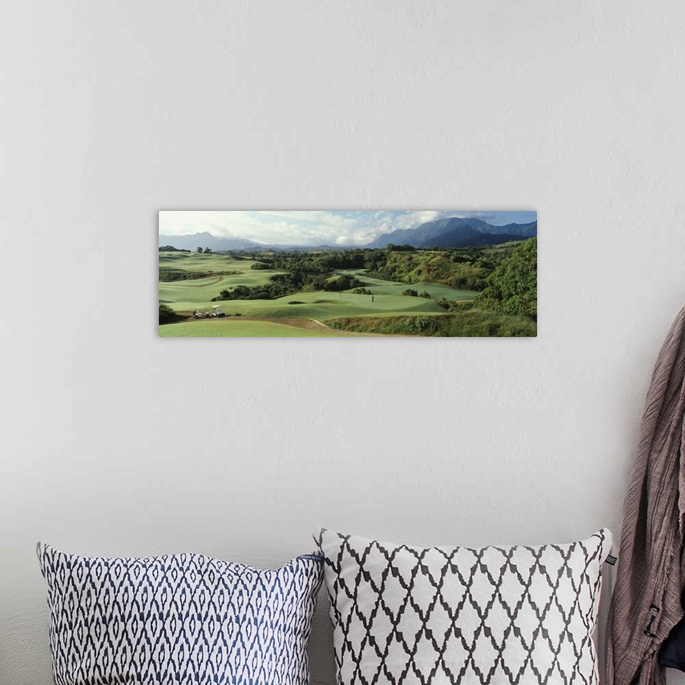 A bohemian room featuring Panoramic picture of rolling hills of a golf course nestled in the Hawaiian mountains.