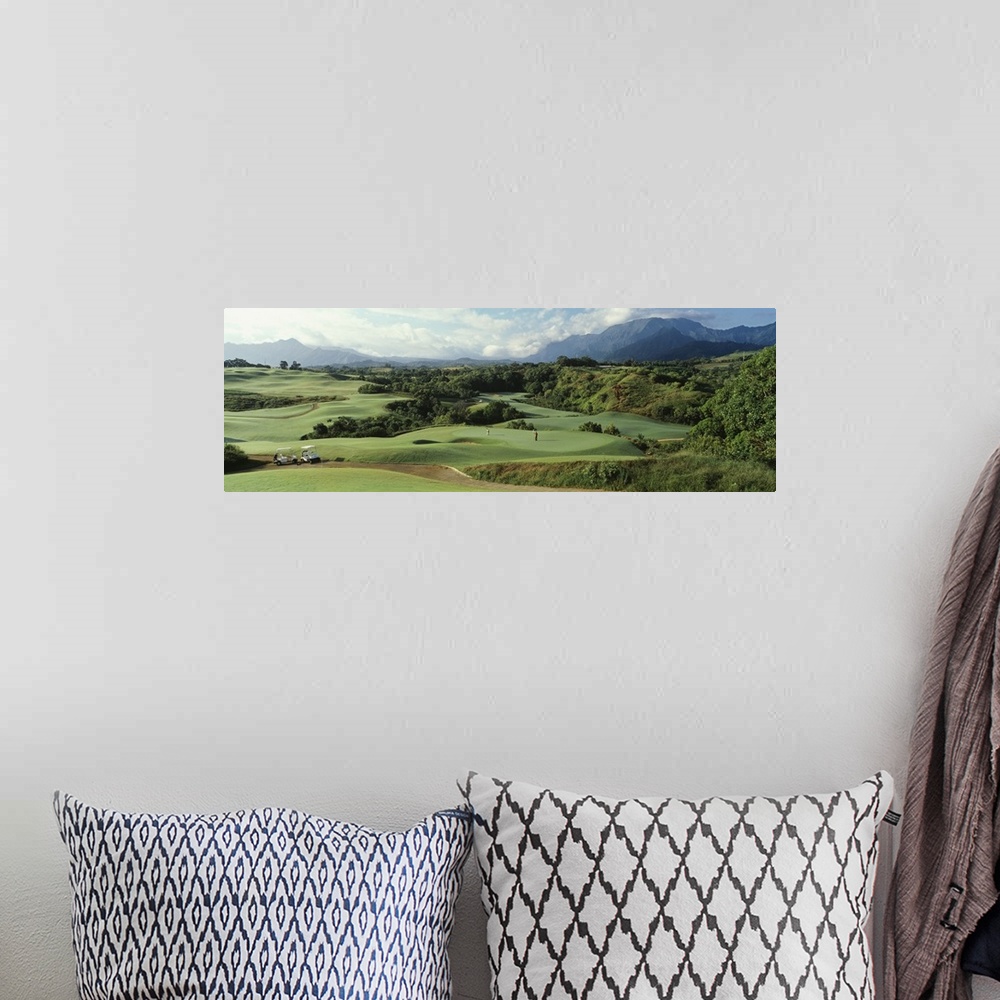 A bohemian room featuring Panoramic picture of rolling hills of a golf course nestled in the Hawaiian mountains.