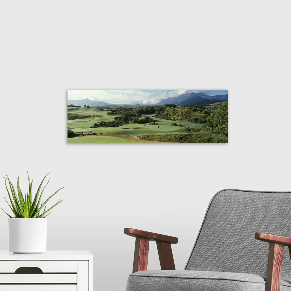 A modern room featuring Panoramic picture of rolling hills of a golf course nestled in the Hawaiian mountains.