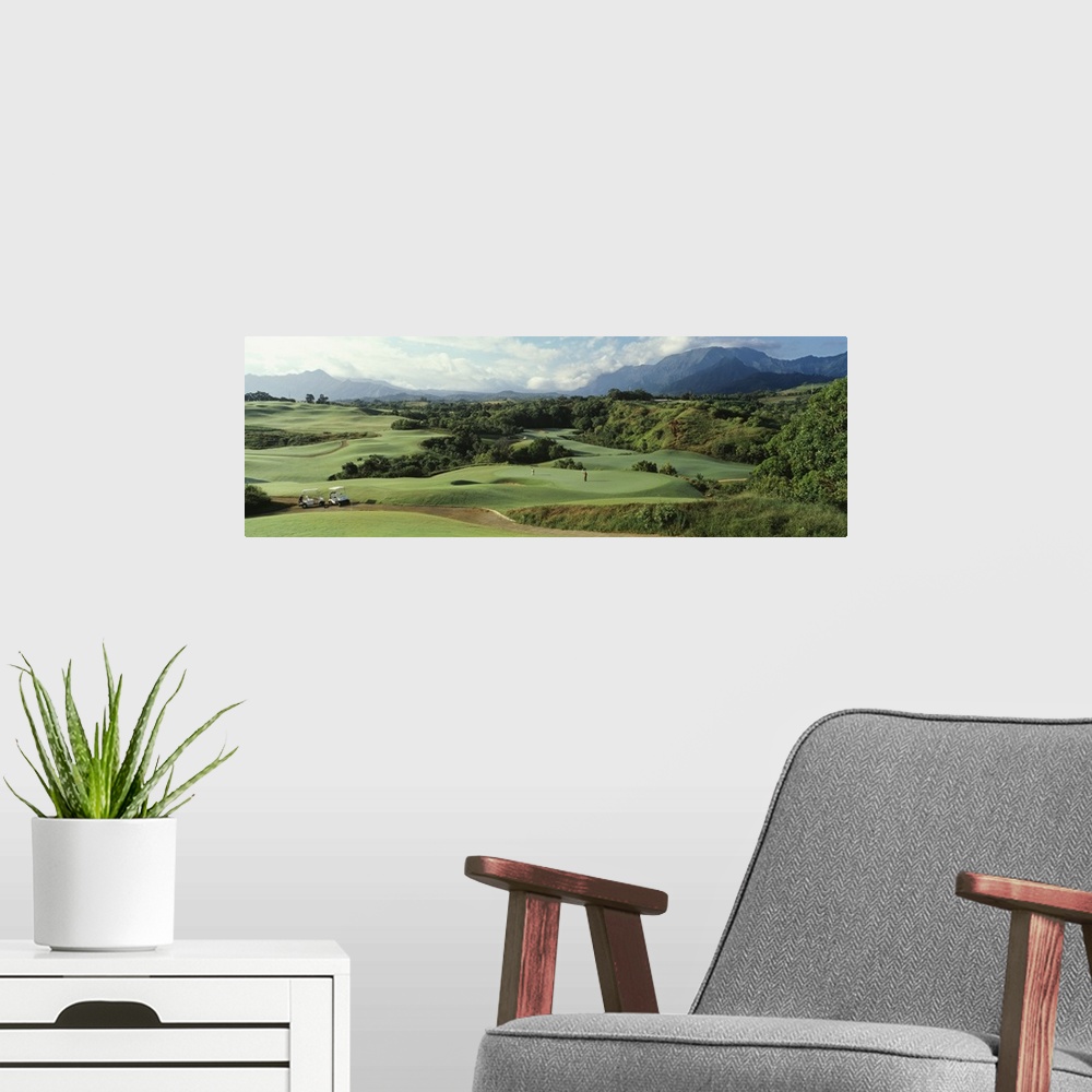 A modern room featuring Panoramic picture of rolling hills of a golf course nestled in the Hawaiian mountains.