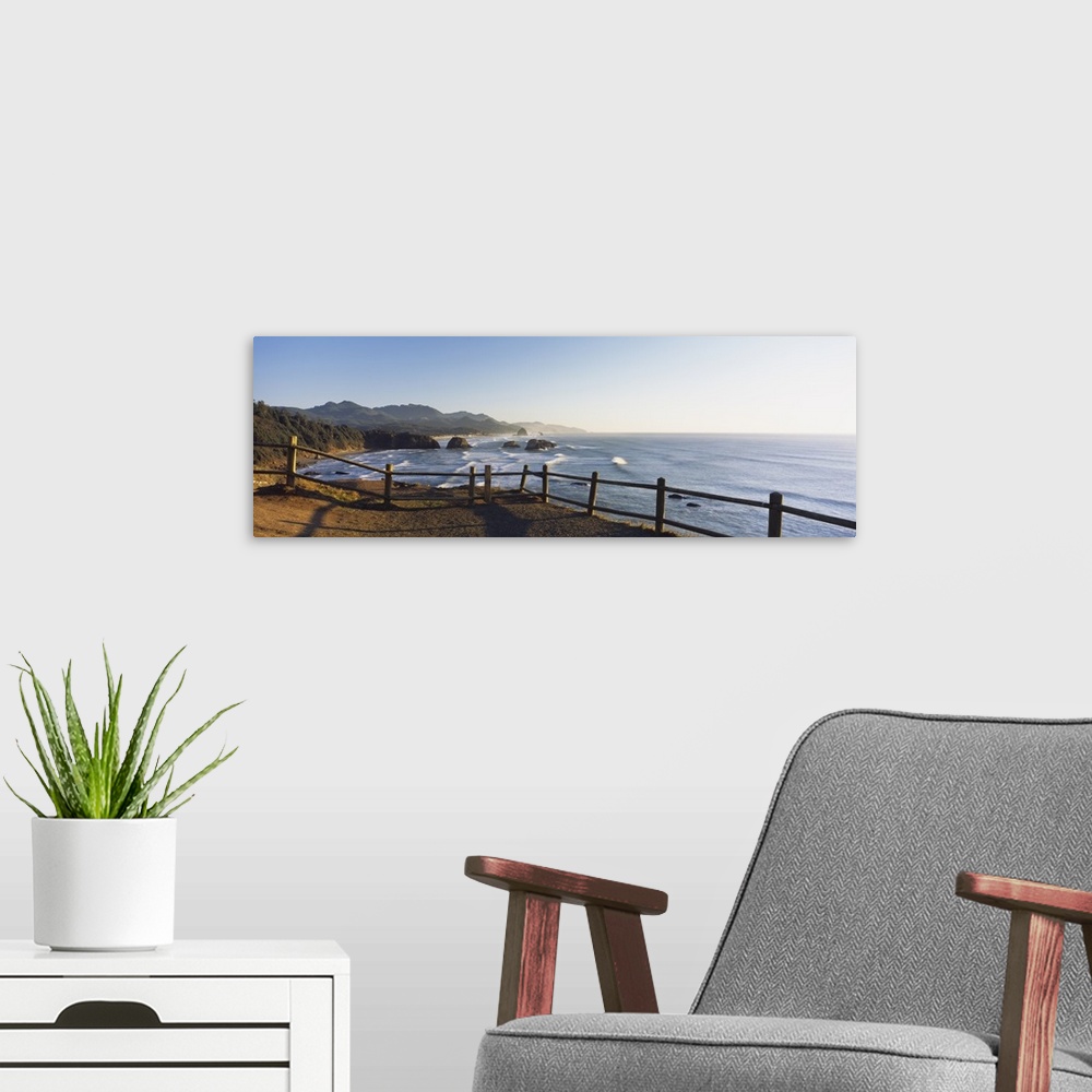 A modern room featuring Giant panoramic photograph featuring a railing overlooking Cannon Beach in Oregon (OR) on a sunny...