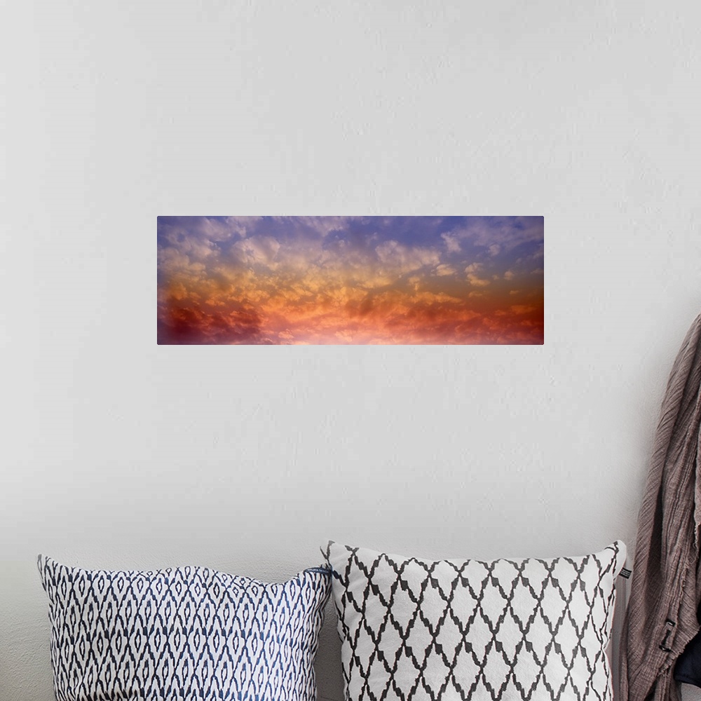 A bohemian room featuring Panoramic photograph of colorful clouds illuminated by the sun.
