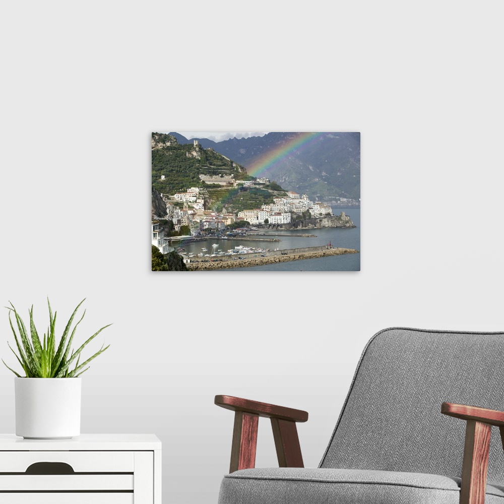 A modern room featuring This is a picture of a rainbow over a town off a coast in Italy. Large white buildings line the w...