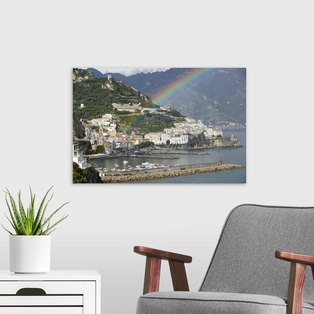 A modern room featuring This is a picture of a rainbow over a town off a coast in Italy. Large white buildings line the w...