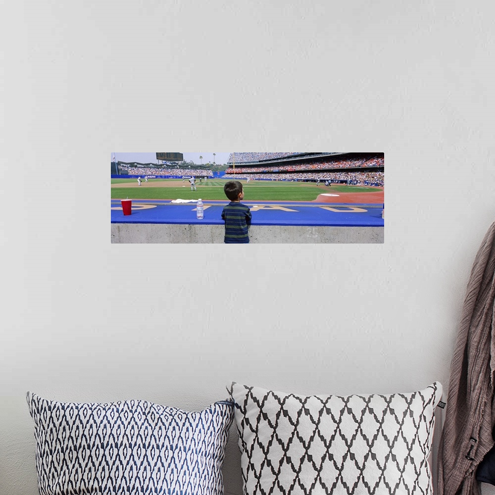 A bohemian room featuring This decorative all wart is a panoramic photograph of a child watching a baseball game from a dug...