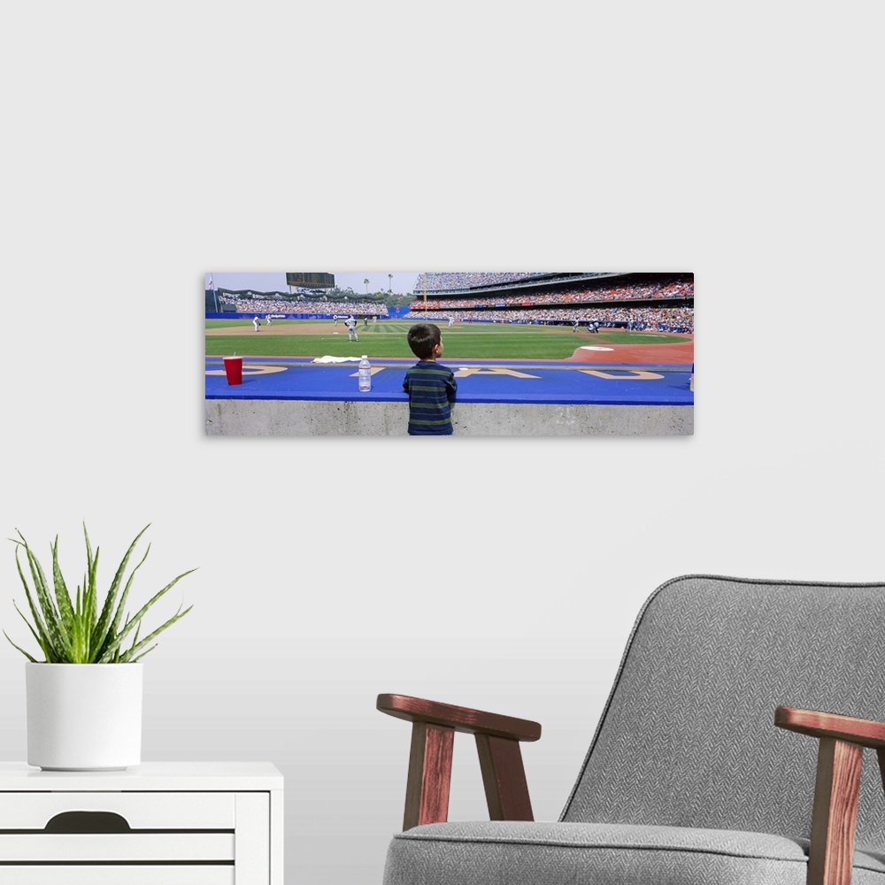 A modern room featuring This decorative all wart is a panoramic photograph of a child watching a baseball game from a dug...