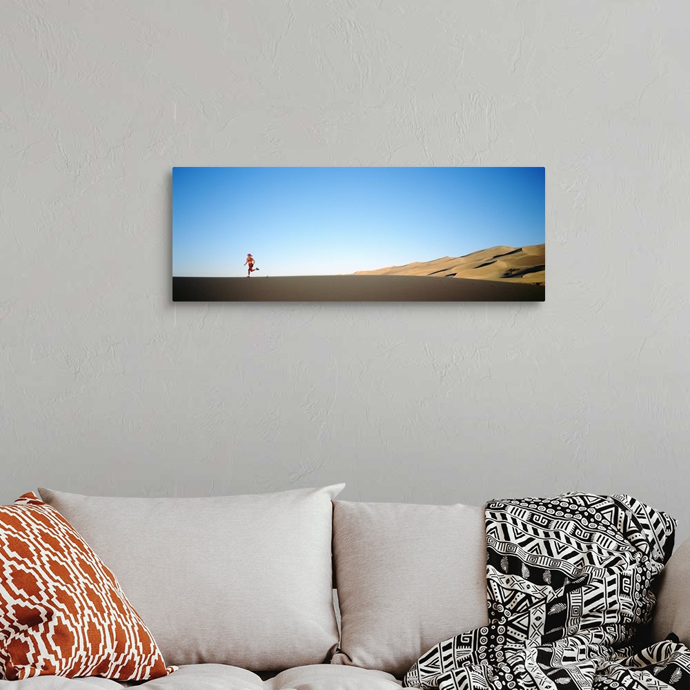 A bohemian room featuring Rear view of a woman running in the desert, Great Sand Dunes National Monument, Colorado