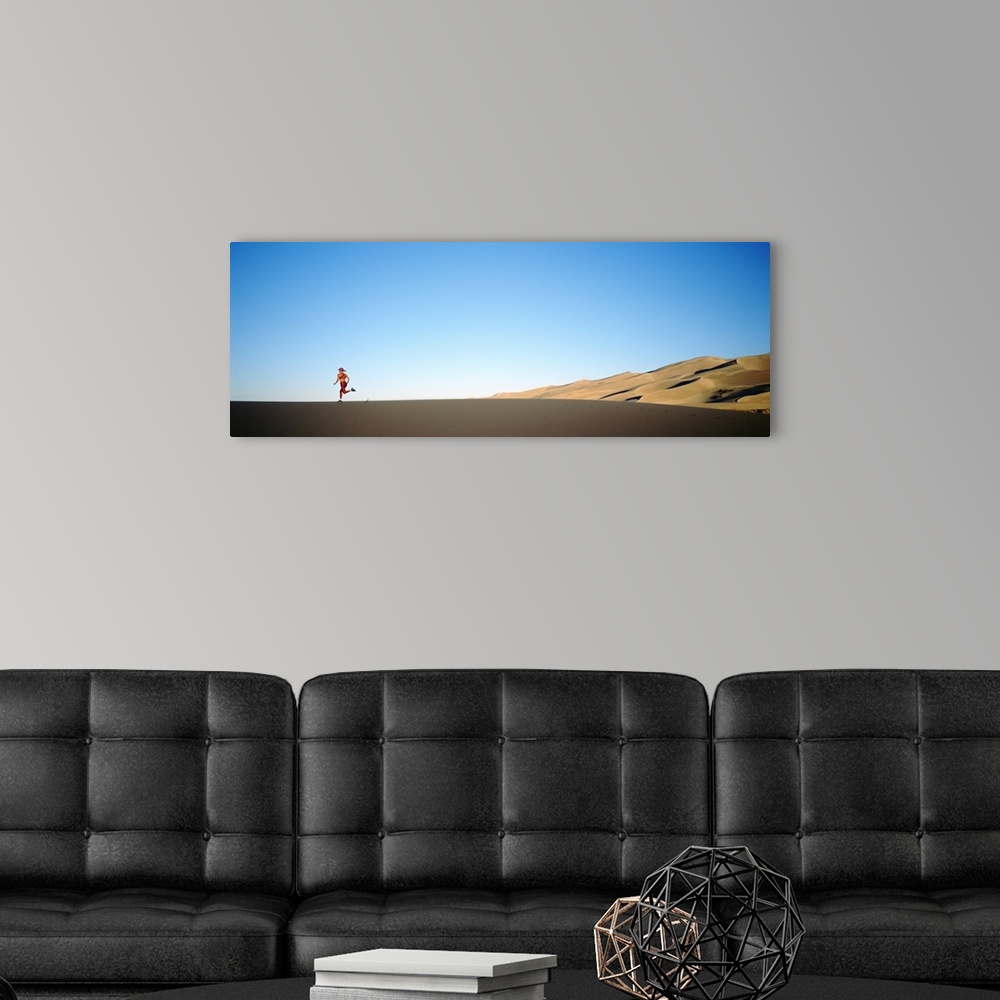 A modern room featuring Rear view of a woman running in the desert, Great Sand Dunes National Monument, Colorado
