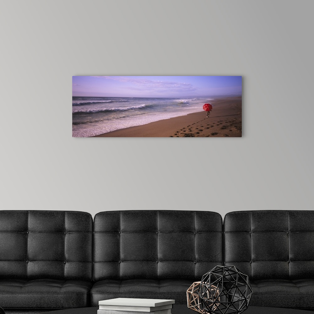 A modern room featuring Rear view of a woman walking on the beach with a red umbrella, Point Reyes National Seashore, Cal...
