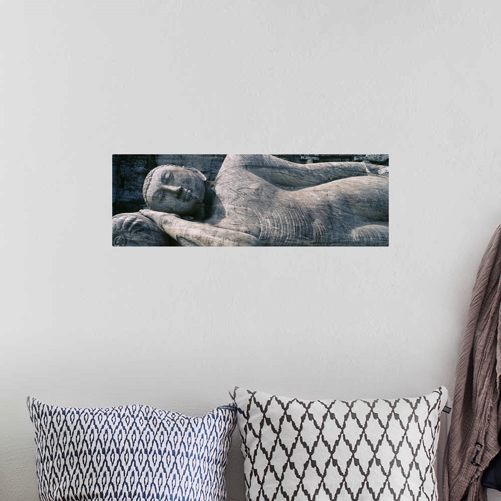 A bohemian room featuring Panoramic photograph taken of a huge sleeping Buddha statue.