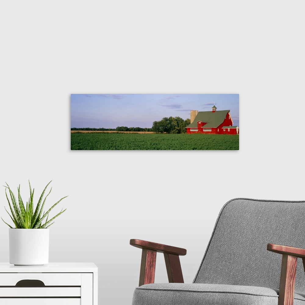 A modern room featuring Panoramic image print of a barn in the middle of a crop field.
