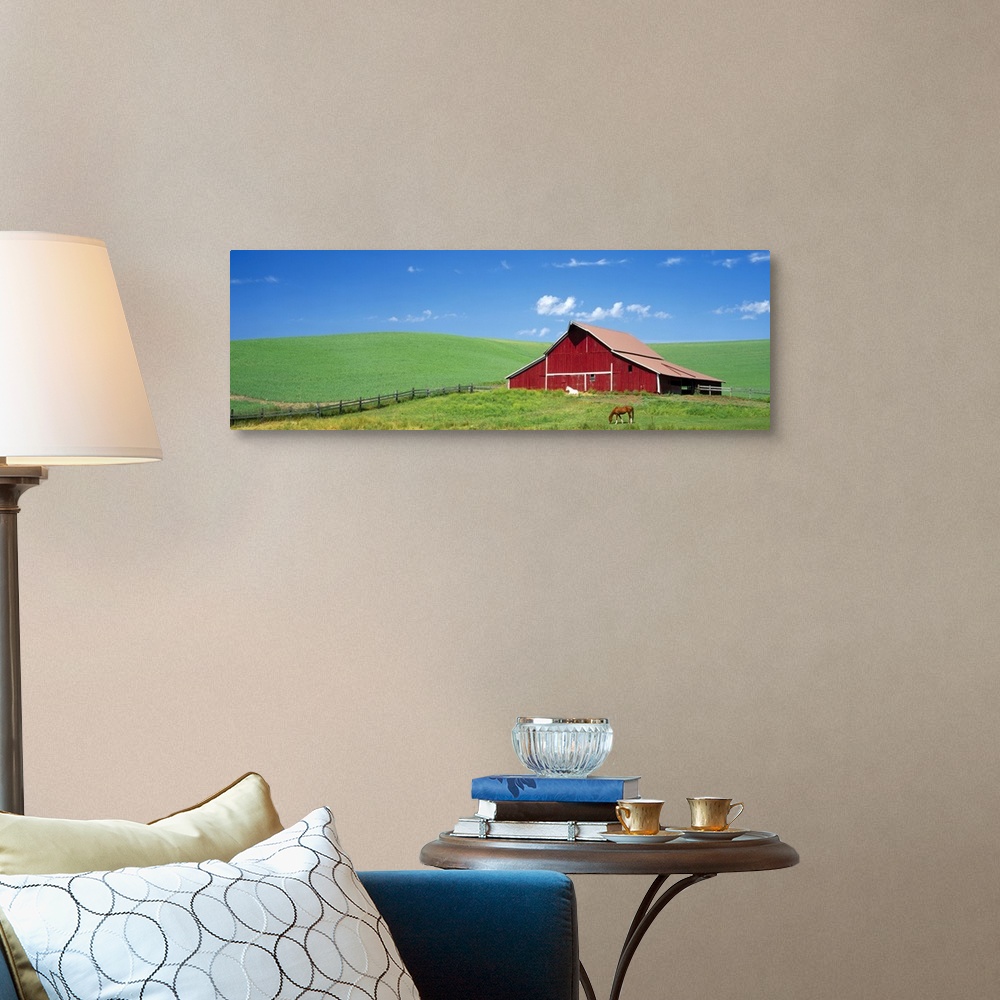 A traditional room featuring Empty farmland, gently rolling hills, and single structure with two horses photographed from a di...