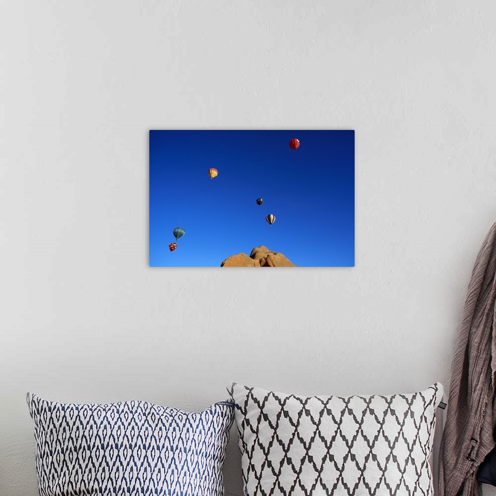 A bohemian room featuring Red rock cliffs, hot air balloons in blue sky, Gallup, New Mexico
