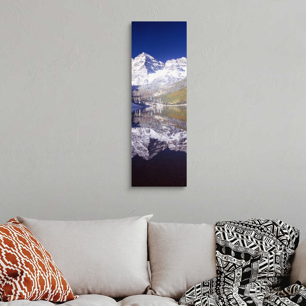 A bohemian room featuring Vertical panoramic photograph of snow covered mountain that is reflected in the water below.