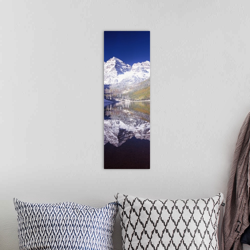 A bohemian room featuring Vertical panoramic photograph of snow covered mountain that is reflected in the water below.