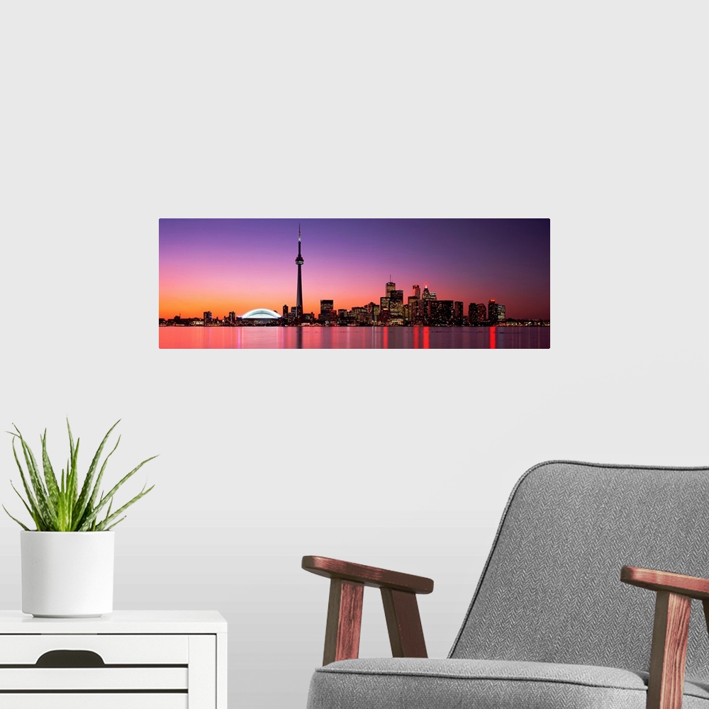A modern room featuring A panoramic photograph of the city skyline glowing in the night.