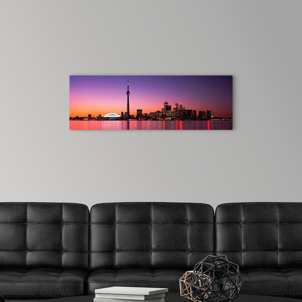A modern room featuring A panoramic photograph of the city skyline glowing in the night.