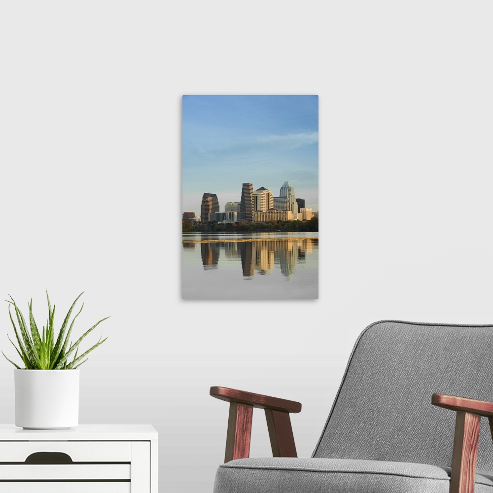 A modern room featuring Skyscrapers in Austin reflect down in the body of water that sits just in front of the city.