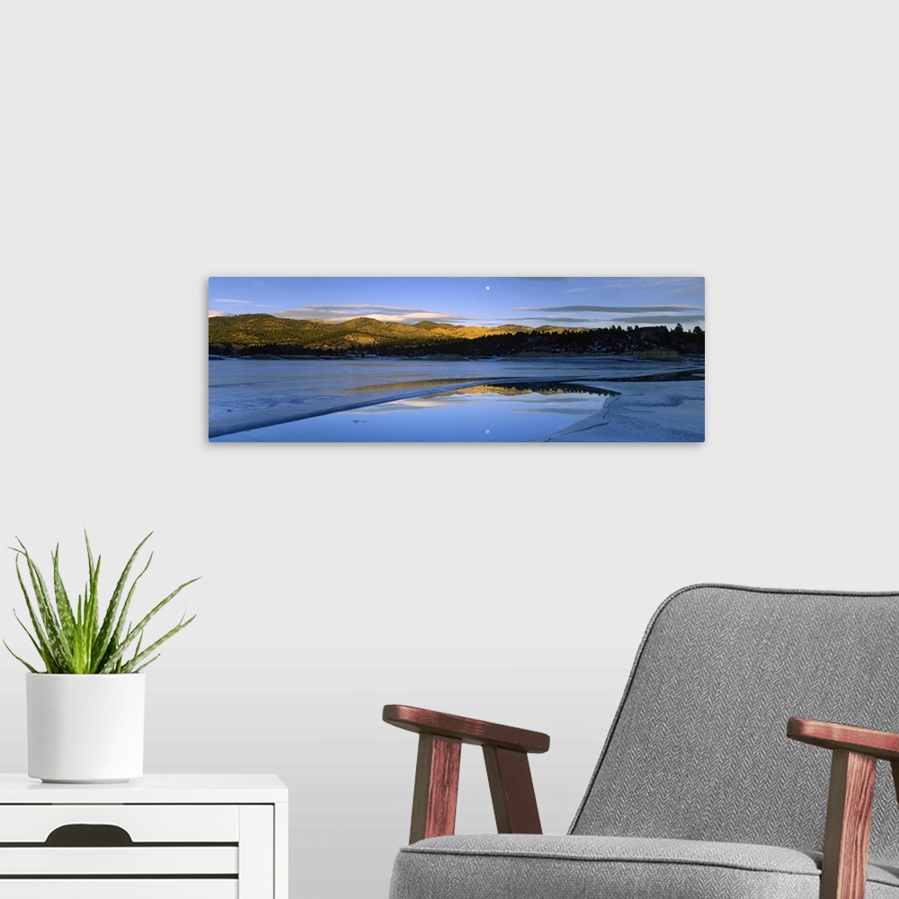 A modern room featuring Large photo on canvas of a lake with rolling hills in the distance and a moon shining bright in t...