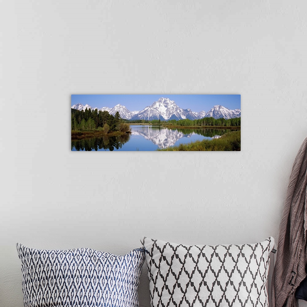 A bohemian room featuring Panoramic photograph on a giant canvas of mountain reflections in the Snake River, surrounded by ...