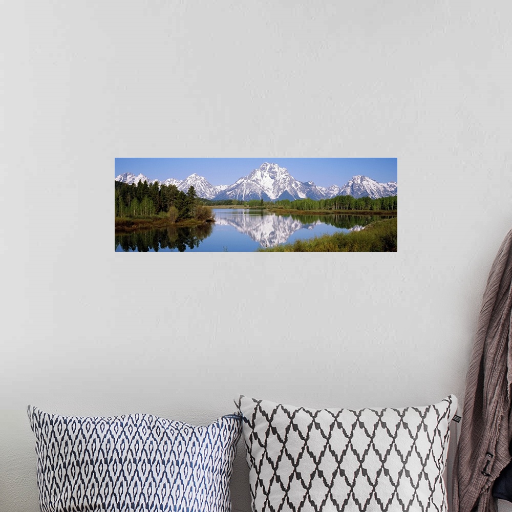 A bohemian room featuring Panoramic photograph on a giant canvas of mountain reflections in the Snake River, surrounded by ...