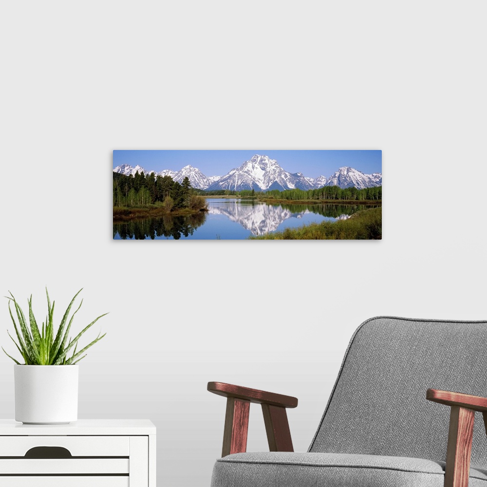 A modern room featuring Panoramic photograph on a giant canvas of mountain reflections in the Snake River, surrounded by ...