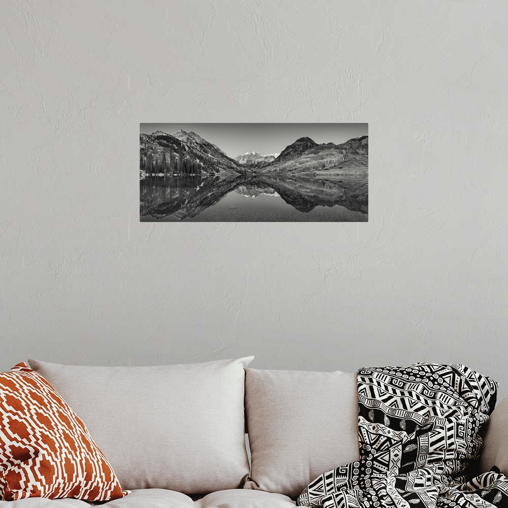 A bohemian room featuring Black and white photograph taken of large mountains and terrain that reflect perfectly in the sti...