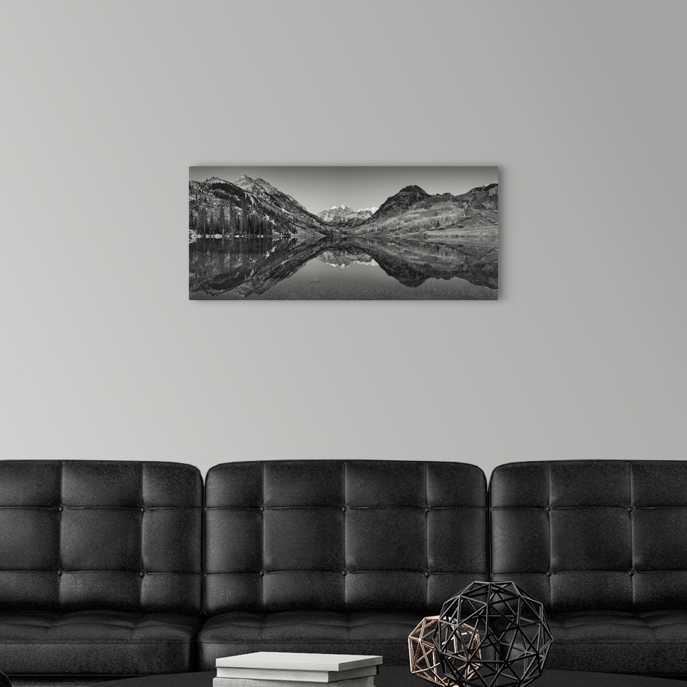 A modern room featuring Black and white photograph taken of large mountains and terrain that reflect perfectly in the sti...