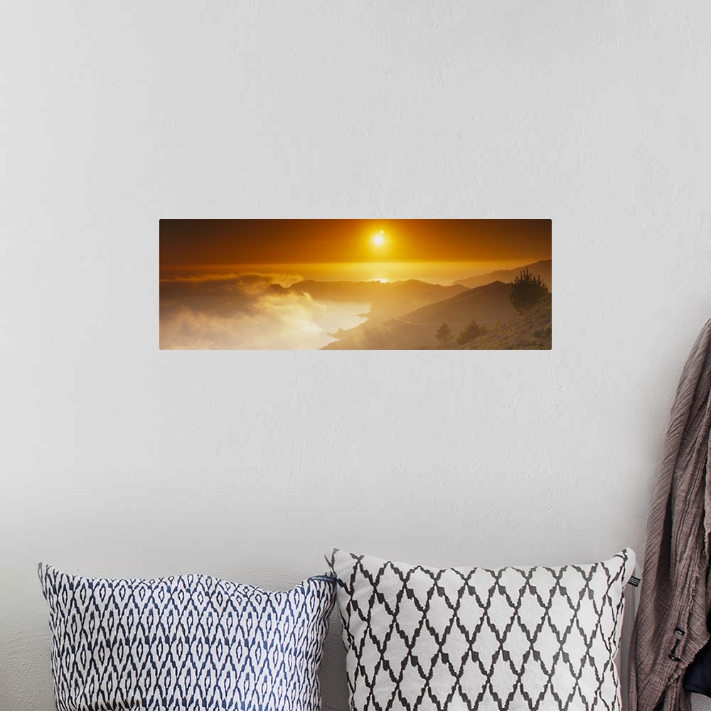 A bohemian room featuring Panoramic photo on canvas of the sun shining bright in the sky above an ocean and mountains with ...