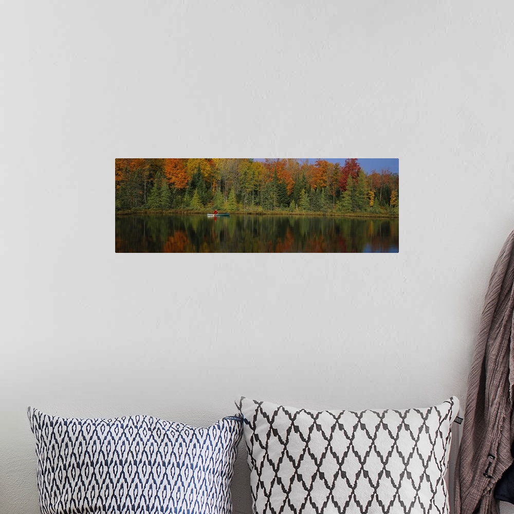 A bohemian room featuring A lone canoer on the lake during the fall in Antigo, Wisconsin.