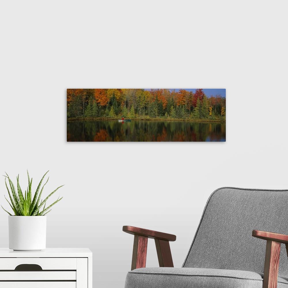 A modern room featuring A lone canoer on the lake during the fall in Antigo, Wisconsin.