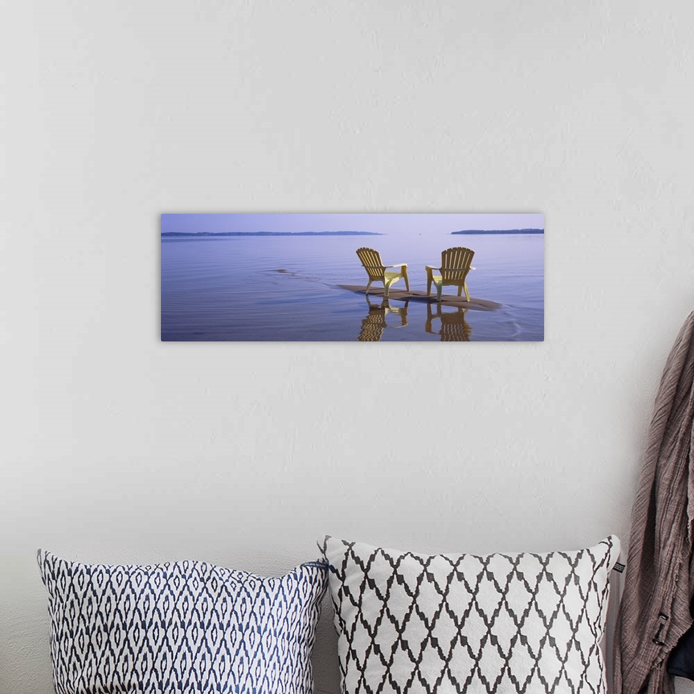 A bohemian room featuring Panoramic photograph of two beach chairs sitting on top of sand bar with land in the far distance.