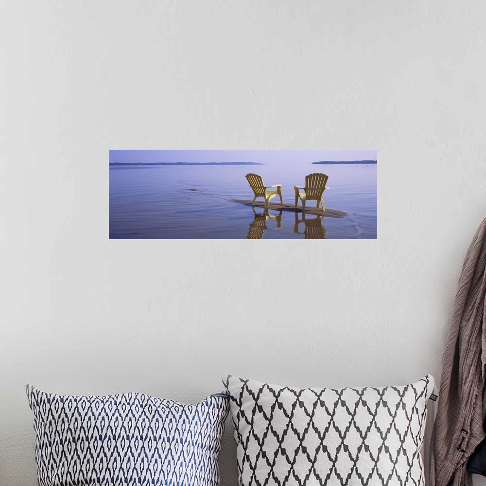 A bohemian room featuring Panoramic photograph of two beach chairs sitting on top of sand bar with land in the far distance.