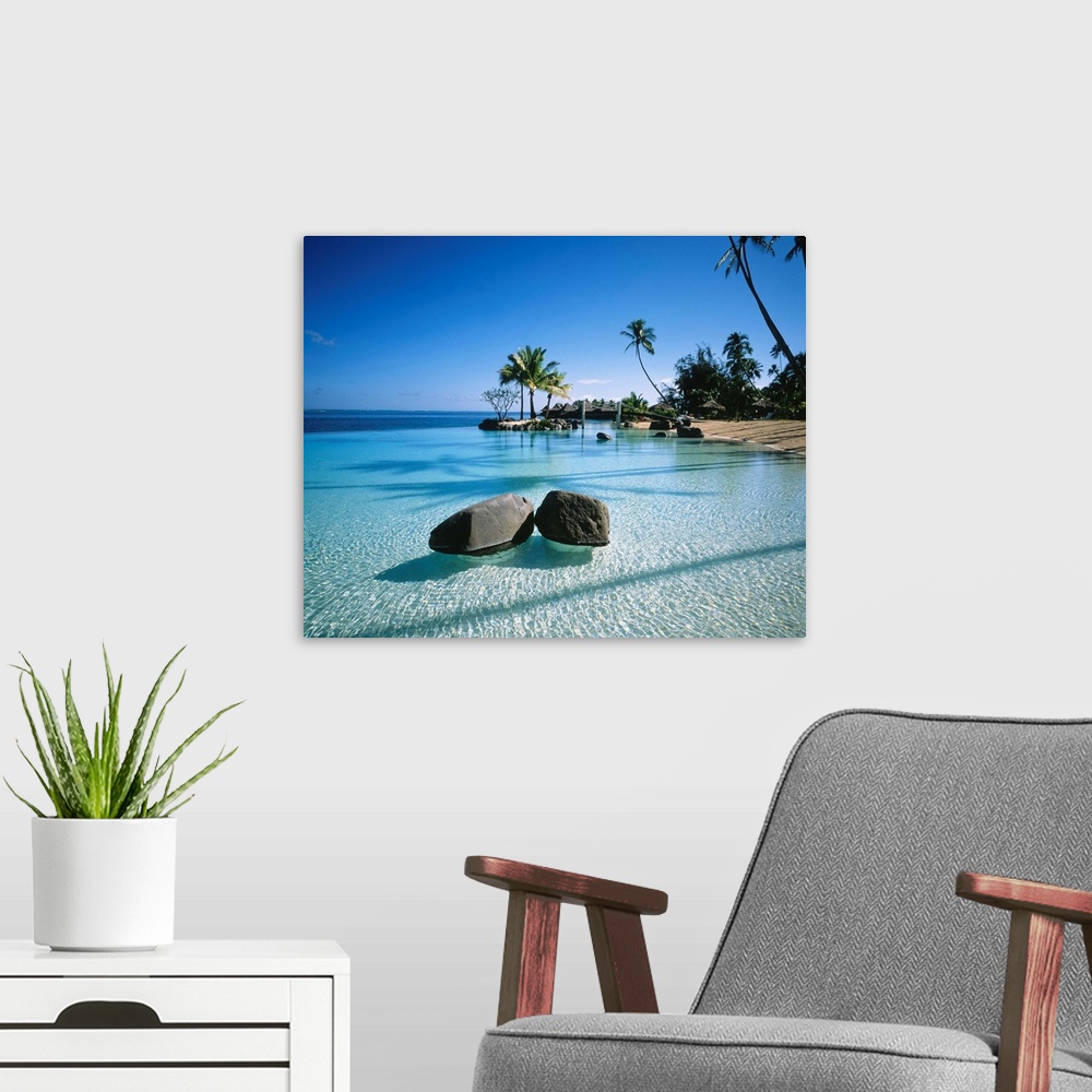 A modern room featuring Large landscape artwork for a living room or office of clear water ripples around rocks on a trop...
