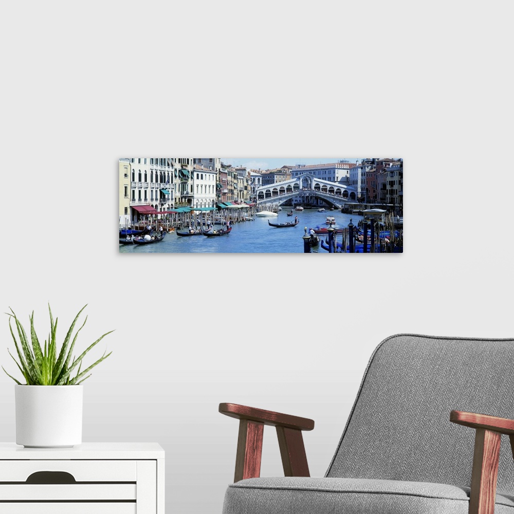 A modern room featuring Panoramic photograph of waterway filled with gondolas and lined with shops and buildings, with ov...