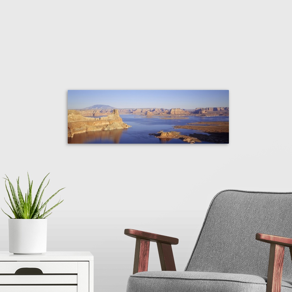 A modern room featuring Panoramic photograph of huge rocks and canyons in river under a clear sky.