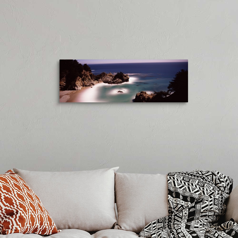 A bohemian room featuring Larges rocks in the water and along the shore  of the Pacific Ocean in Big Sur, California.