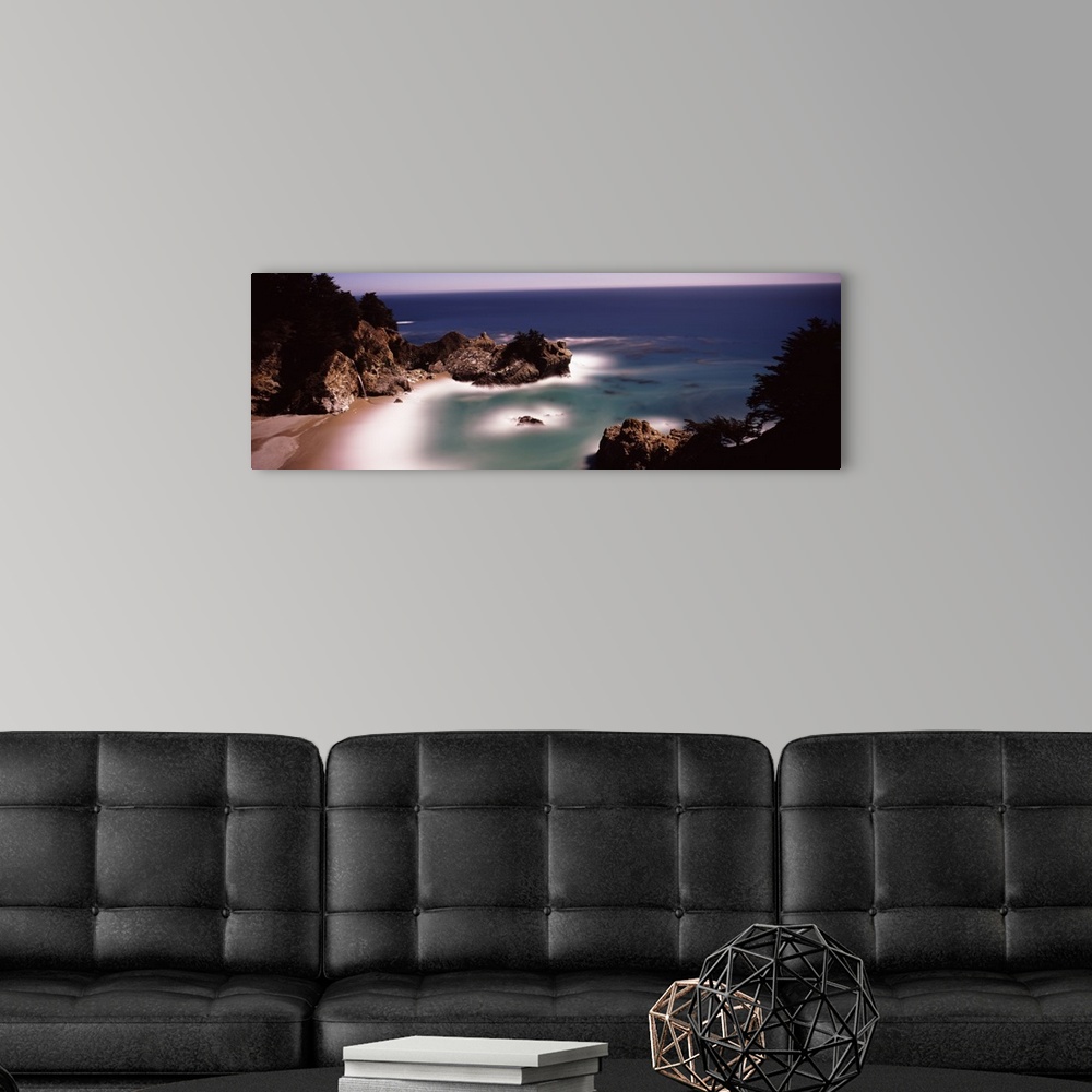 A modern room featuring Larges rocks in the water and along the shore  of the Pacific Ocean in Big Sur, California.
