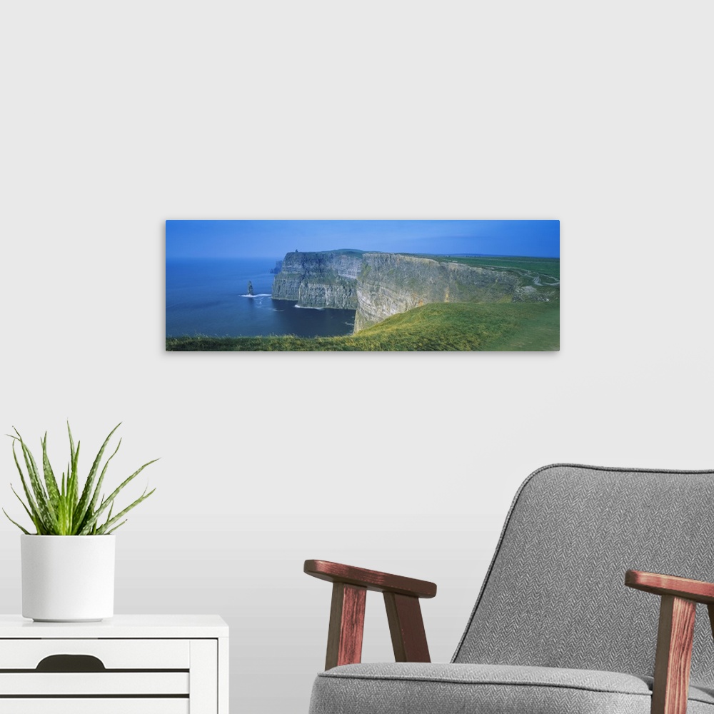 A modern room featuring Wide angle photograph of curving, large rock formations of the Cliffs of Moher, leading into the ...