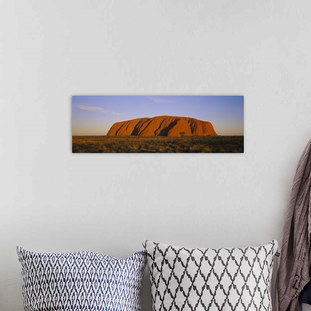 A bohemian room featuring A large sandstone landmark rises out of the desert plains in this panorama photographic wall art.