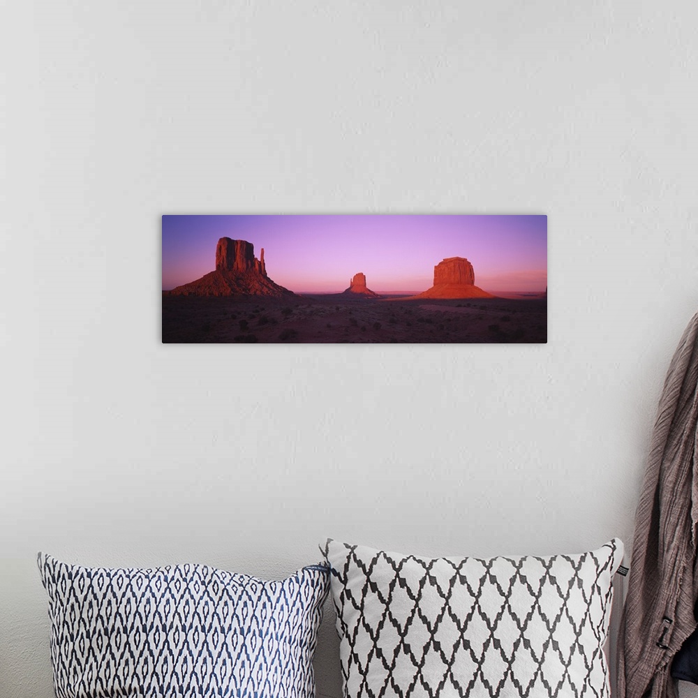 A bohemian room featuring Rock formations on an arid landscape at dusk, Monument Valley, Utah