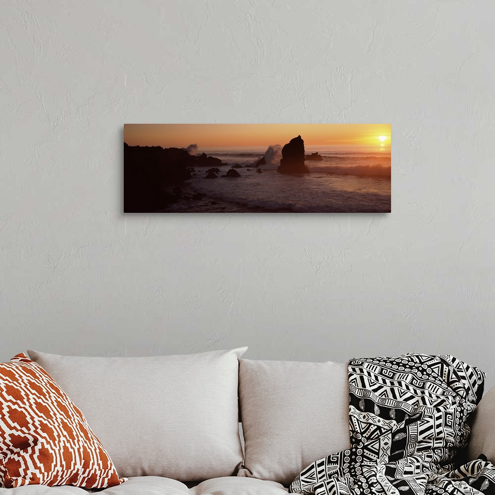 A bohemian room featuring Panoramic photo on canvas of rock formations on a beach with waves breaking on the shore at sunset.