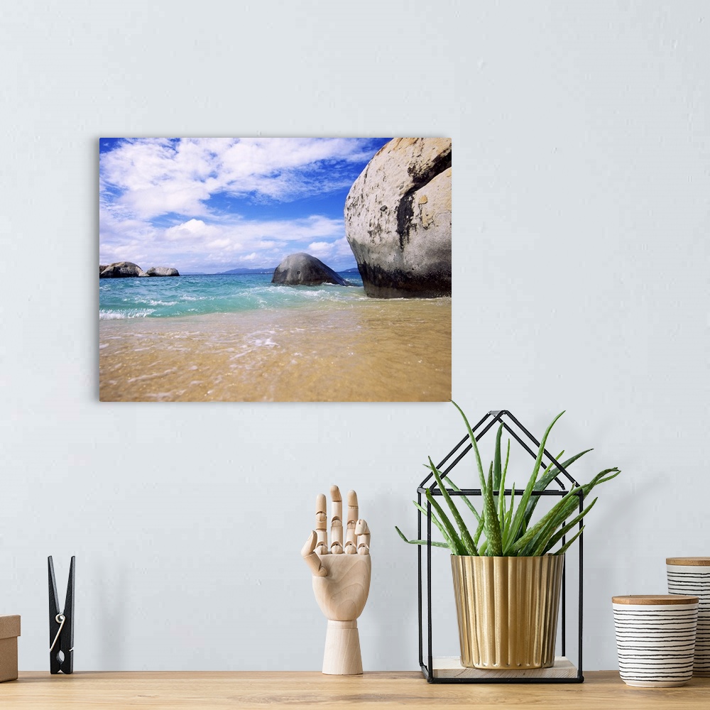 A bohemian room featuring This landscape photograph taken at ground level shows waves rocking against the sandy shore and l...