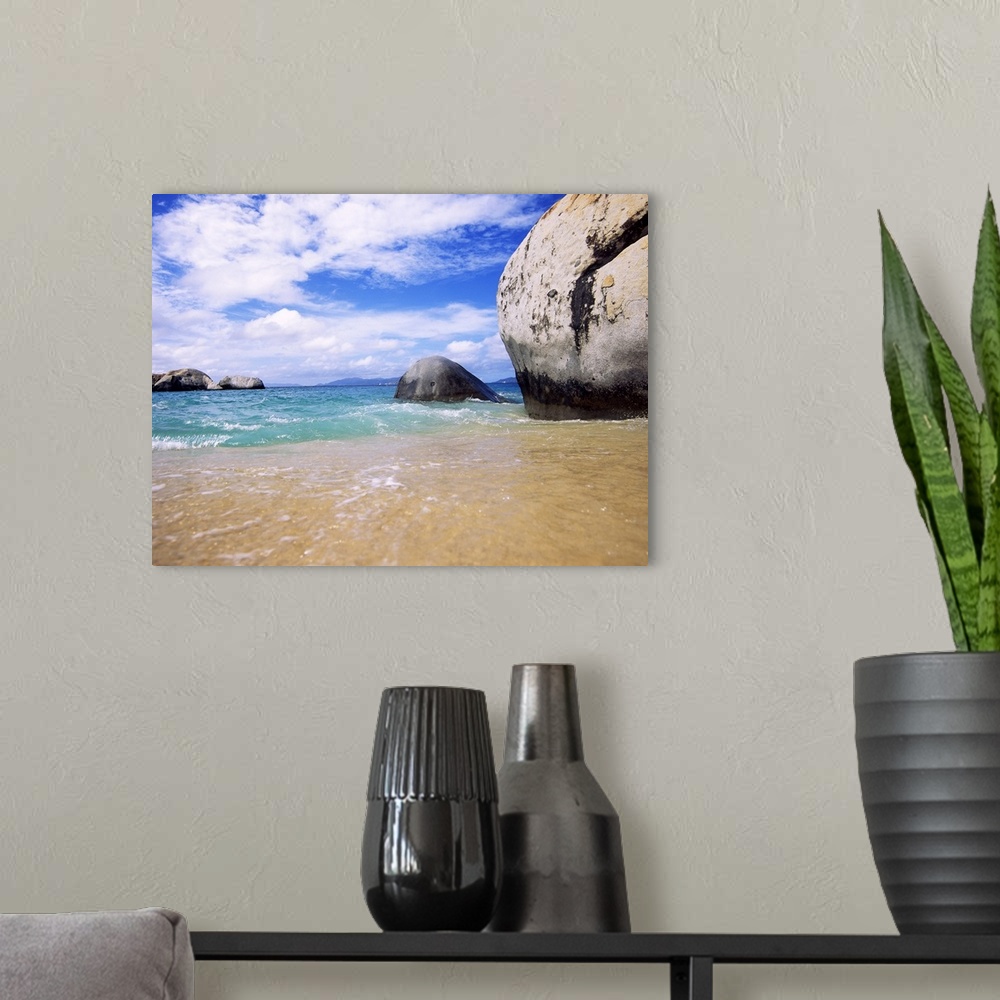 A modern room featuring This landscape photograph taken at ground level shows waves rocking against the sandy shore and l...